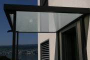 Glasvordach mit Metallstützen
